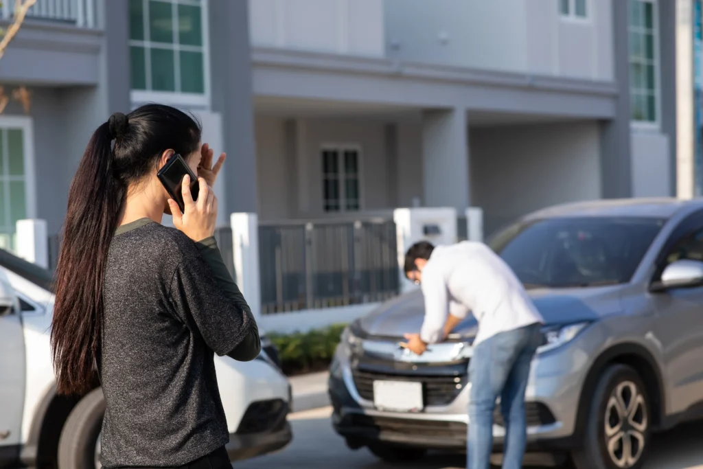 Two drivers checking their cars after an accident.
