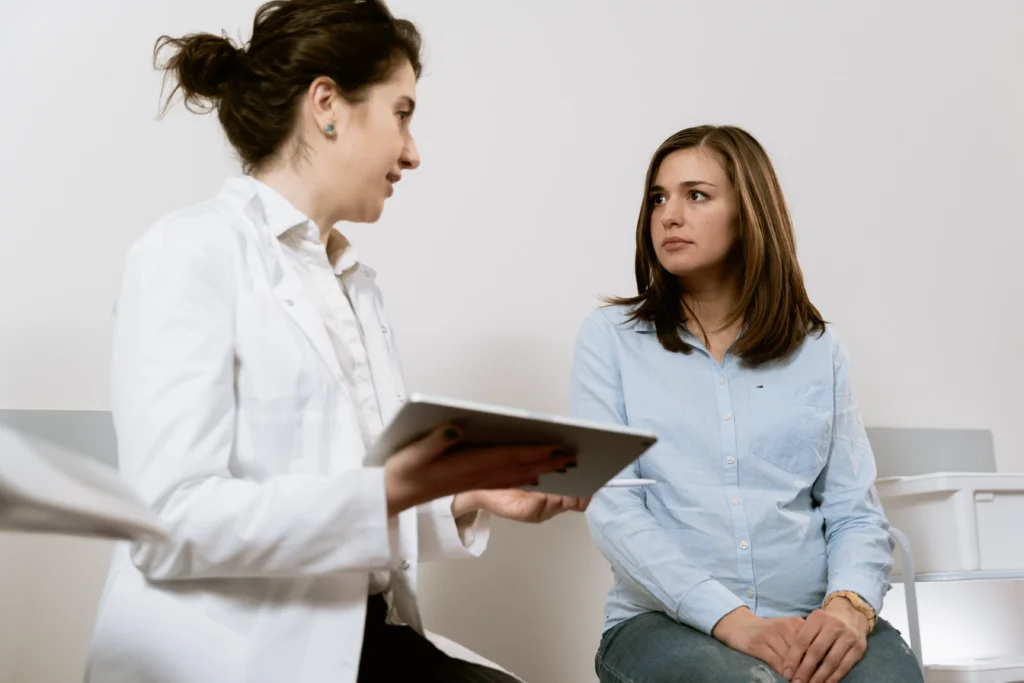 A doctor holding a file, talks with a patient.